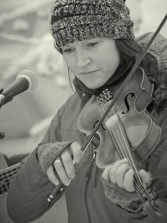 Black and white photo of Aurora playing fiddle in the winter